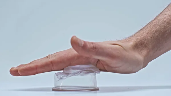 Vista parcial del hombre presionando taza de plástico en gris, cero concepto de residuos - foto de stock