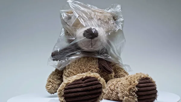 Plastic bag on teddy bear isolated on grey — Stock Photo