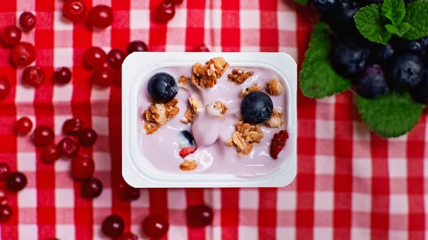 Top view of fresh berries on top of yogurt with granola in plastic container — Stock Photo