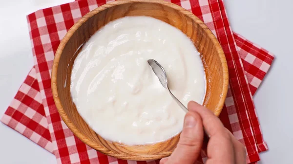 Top view of man holding spoon with yogurt near bowl isolated on white — Stock Photo