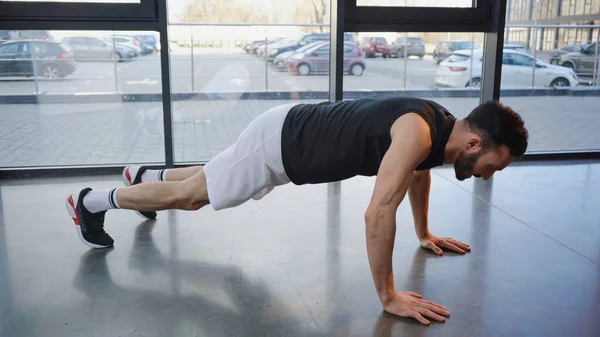 Side view of sportsman doing press ups in gym — Stock Photo