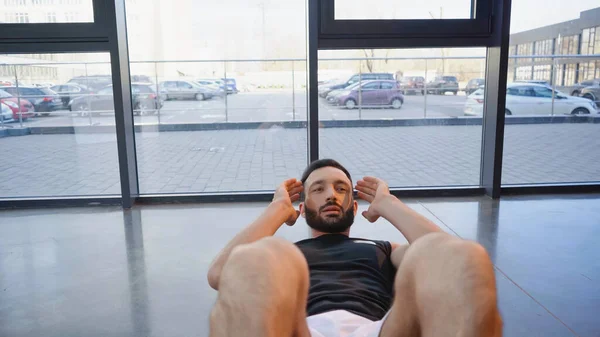 Deportista barbudo haciendo abdominales en el gimnasio - foto de stock
