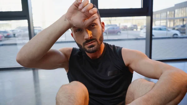 Esportista cansado olhando para a câmera no ginásio — Fotografia de Stock