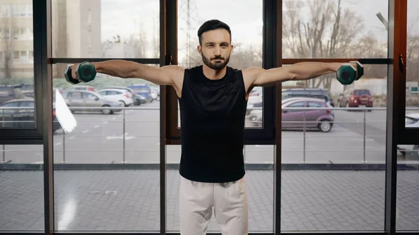 Allenamento di sportivi muscolari bruni con manubri nel centro sportivo — Foto stock