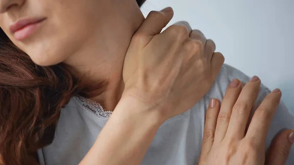 Vue partielle de la femme touchant le cou tout en ressentant une douleur isolée sur le gris — Photo de stock