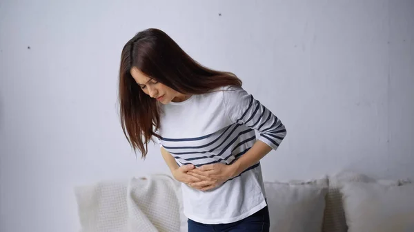 Upset woman touching belly while suffering from stomach pain — Stock Photo