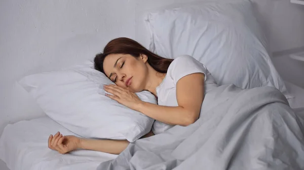 Mulher morena dormindo na cama de manhã — Fotografia de Stock