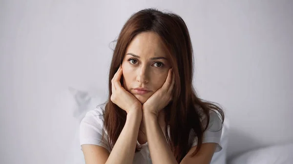 Beleidigte Frau mit händennahem Gesicht blickt in Kamera — Stockfoto