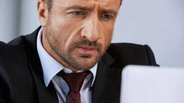 Serious businessman in black suit working in office — Stock Photo