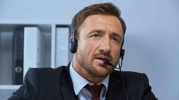Homem em desgaste formal e fone de ouvido trabalhando em call center — Fotografia de Stock