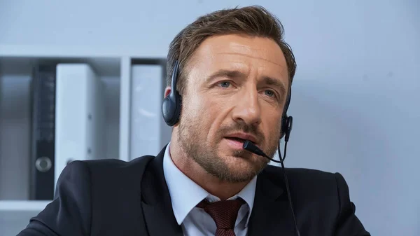 Uomo in abbigliamento formale e auricolare che lavora in call center — Foto stock