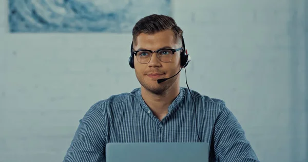 Teleworker in headset with microphone and glasses working from home — Stock Photo