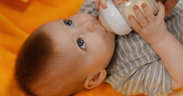 High angle view of infant boy drinking milk from baby bottle — Foto stock