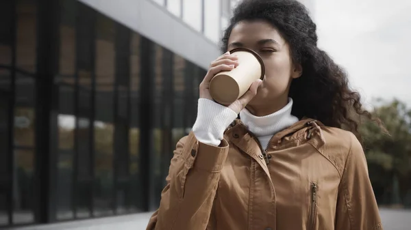 Giovane donna afroamericana che beve caffè per andare in strada — Foto stock