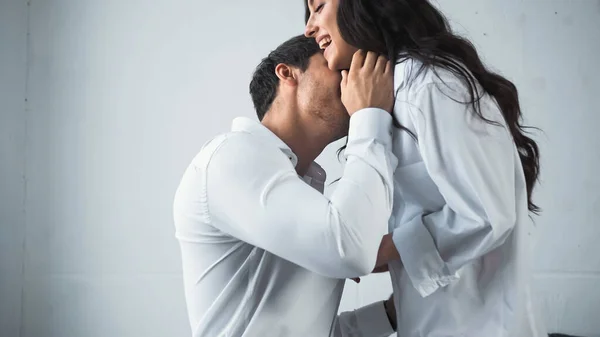 Homem de negócios em camisa branca abraçando e beijando mulher feliz em casa — Fotografia de Stock