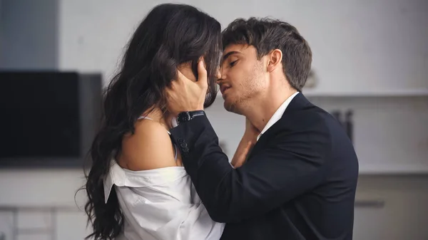 Side view of businessman in suit hugging and kissing girlfriend — Stock Photo