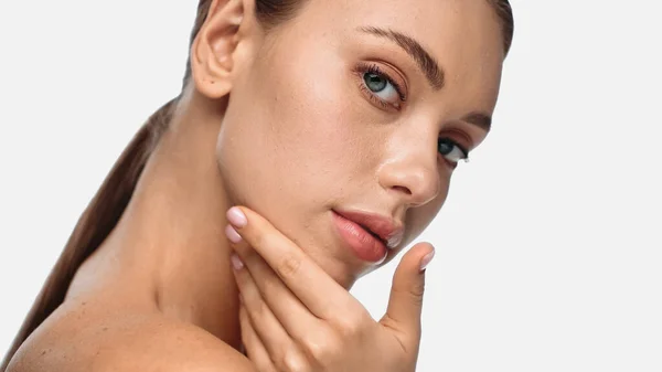 Portrait of pretty young woman with clean skin touching face isolated on white — Photo de stock