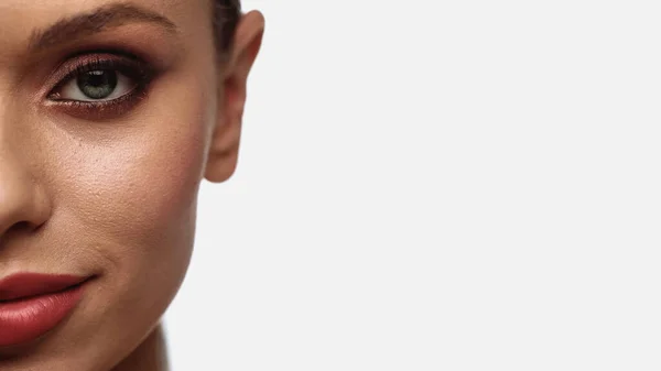 Cropped view of young woman with makeup looking at camera isolated on white — Stockfoto