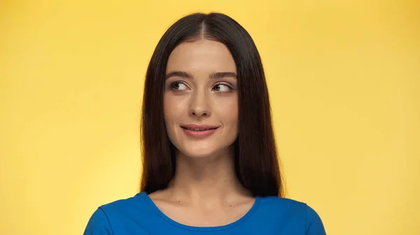 Junge und zufriedene Frau im blauen T-Shirt, die vereinzelt auf gelb wegschaut — Stockfoto