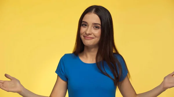 Young and joyful woman in blue t-shirt gesturing isolated on yellow — Foto stock