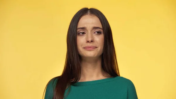 Sad and brunette young woman in green blouse looking away isolated on yellow — Photo de stock