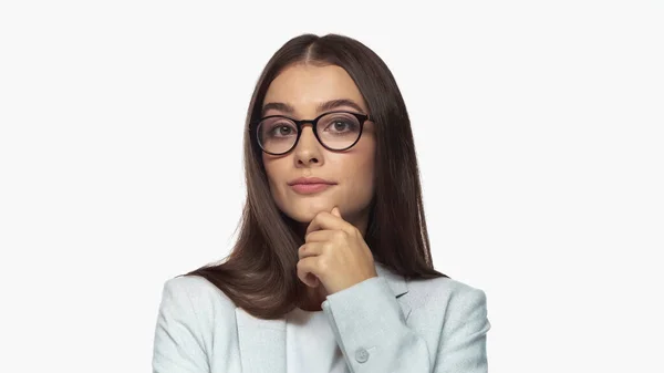 Pretty young businesswoman in grey blazer and eyeglasses looking at camera isolated on white — Stock Photo