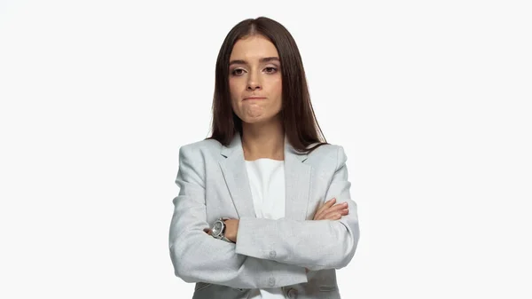 Mulher de negócios descontente em blazer cinza de pé com braços cruzados isolados em branco — Fotografia de Stock