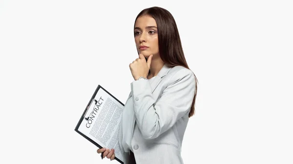 Pensive businesswoman in grey blazer holding clipboard with contract isolated on white — Stock Photo