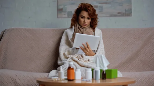 Mulher ruiva usando tablet digital perto da mesa com medicação — Fotografia de Stock