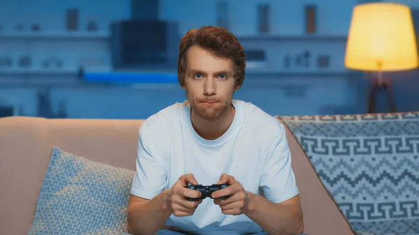 KYIV, UKRAINE - MARCH 12, 2019: focused young man playing video game in living room — Foto stock