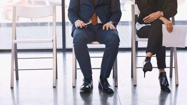 Cropped view of man and woman waiting for job interview in office — Stock Photo