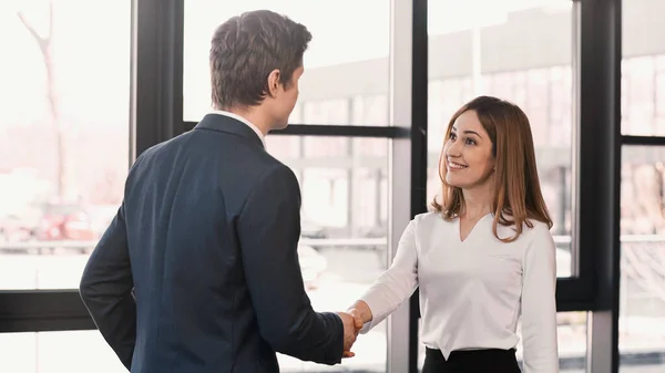 Businessman shaking hands with cheerful woman after job interview — Stock Photo
