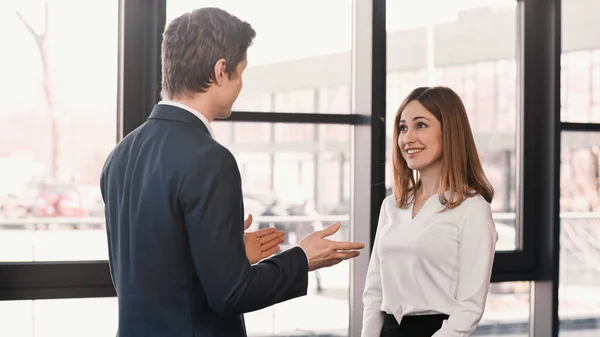 Businessman pointing with hands at happy woman during job interview — Stock Photo