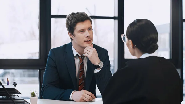 Attentive businessman listening to brunette woman during job interview — Stock Photo