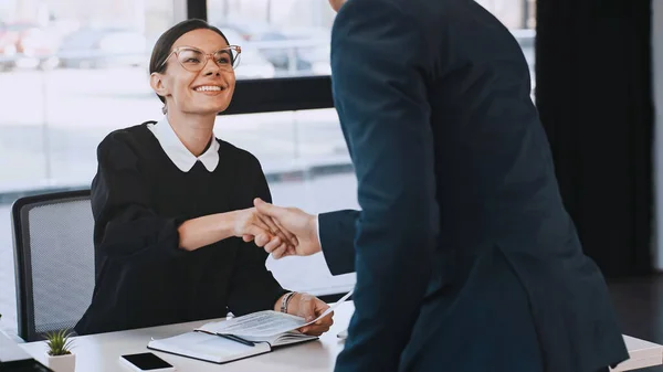 Smiling businesswoman holding resume and shaking hands with man after job interview — Fotografia de Stock