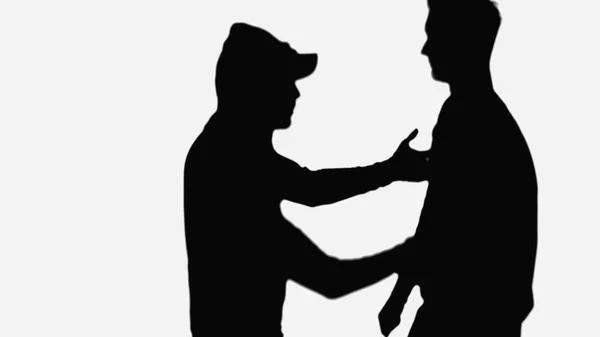 Чорна тінь грабіжника в шапці і капоті нападає на людину ізольовано на білому — стокове фото
