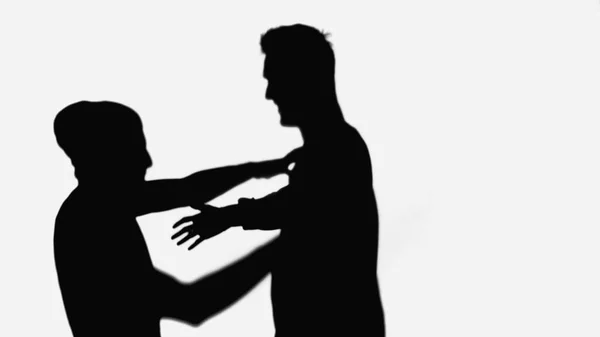 Black silhouettes of friends meeting and embracing isolated on white — Stock Photo
