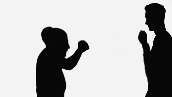 Silhouettes of friends going to do fist bump while greeting each other isolated on white - foto de stock