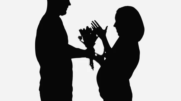 Shadow of man presenting flowers to woman showing wow gesture isolated on white — Stock Photo