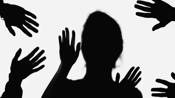 Shadows of hands of people near bullied woman gesturing isolated on white - foto de stock