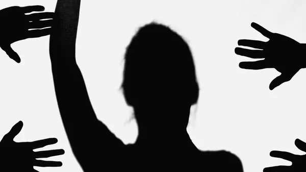 Silhouette of woman with arm up near hands of people isolated on white - foto de stock