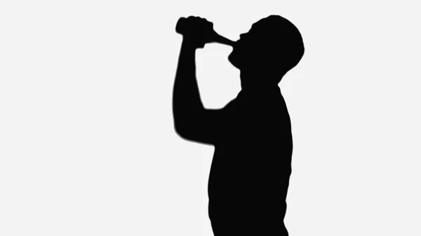 Black shadow of man drinking beer isolated on white — Stock Photo