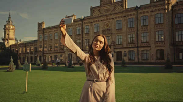 Young woman taking selfie on smartphone in summer park — Stock Photo
