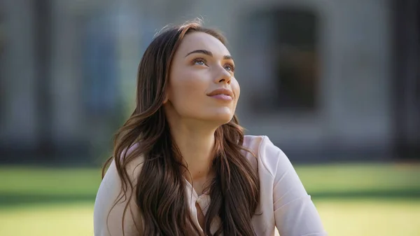 Dreamy brunette woman looking away outdoors — Stock Photo