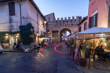 Trastevere Roma İtalya gece. Sokak köşesindeki İtalyan Vespa motosikletinin görüntüsü.