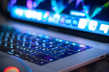 Adam gece bilgisayar klavyesi kullanıyor. İnsan parmakları dizüstü bilgisayarın klavye tuşlarına basıyor.