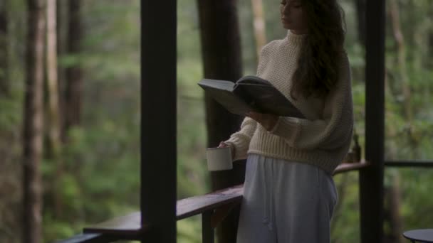 Young Woman Reading Book Drinking Hot Tea Porch Cozy Cabin — Vídeo de Stock