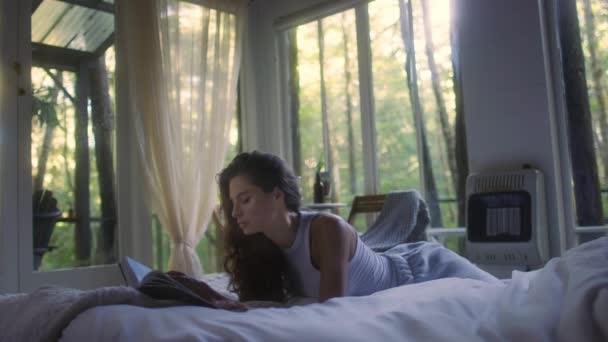 Una Mujer Joven Lee Libro Cama Interior Del Dormitorio Vista Clip De Vídeo