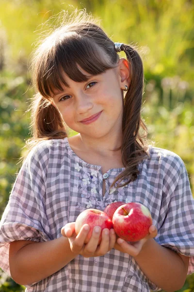Cute dziewczynka z jabłkiem w dłoni — Zdjęcie stockowe