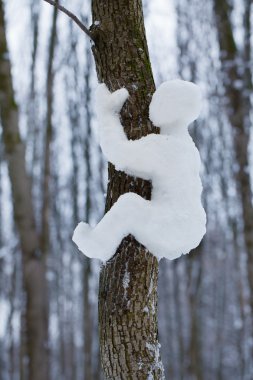 Glare from the snow man crawling on a tree clipart